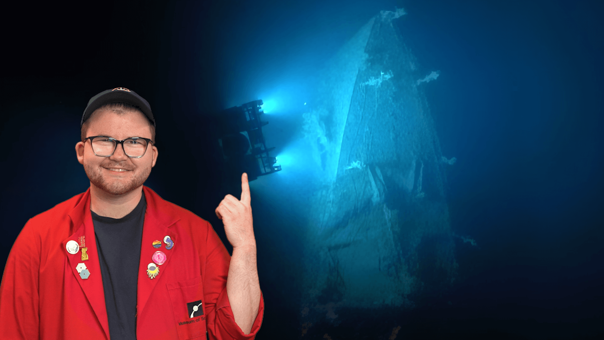 Educator Locke pointing at a shipwreck lit in blue light.