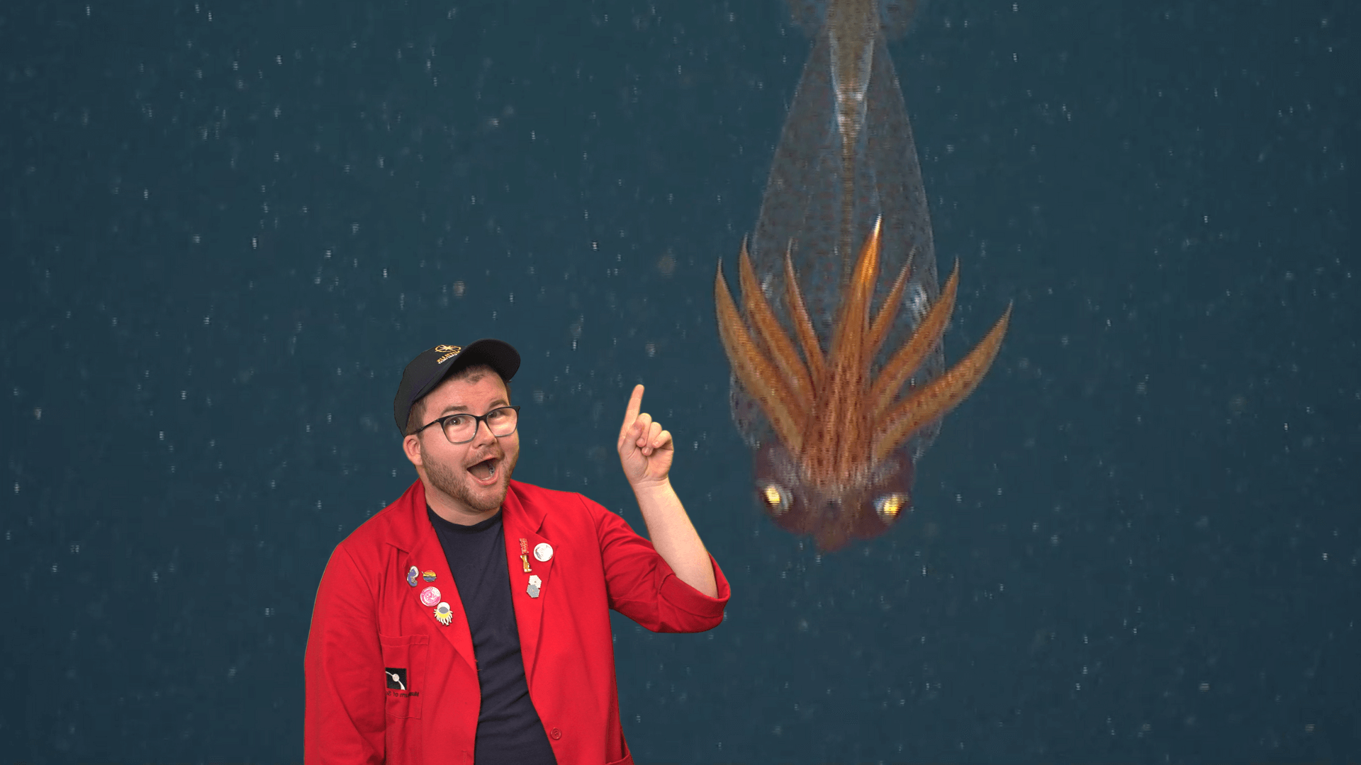 Educator Locke pointing at a glass squid while it swims