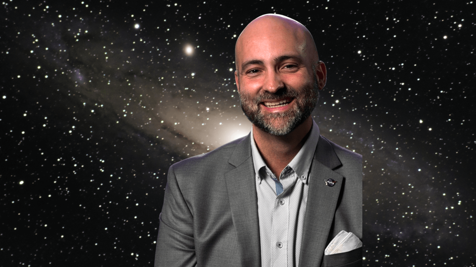 Paul Sutter in front of an image of a galaxy