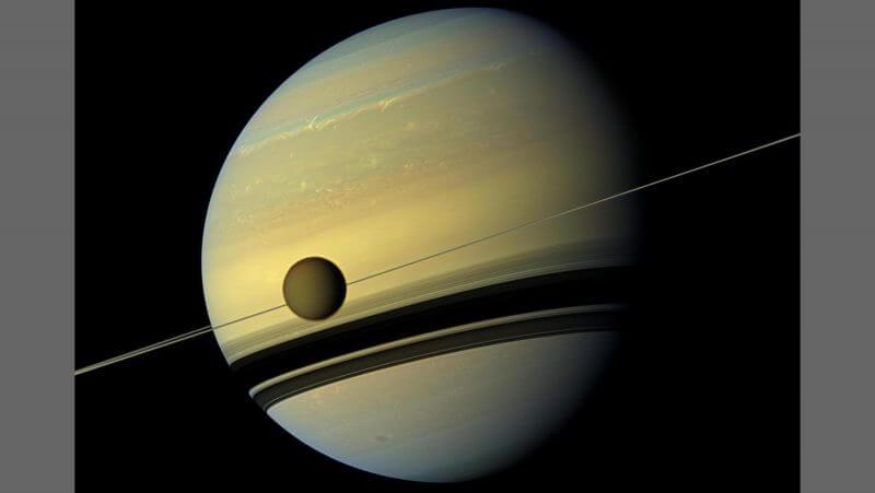 Modern day Titan, seen here in front of Saturn, looks like a fuzzy orange sphere thanks to its thick atmosphere. Credit: NASA/JPL-Caltech/Space Science Institute
