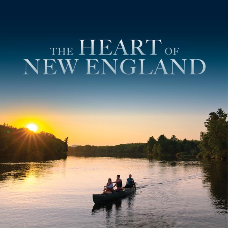 Three people paddeling in a canoe in a river at sunset.