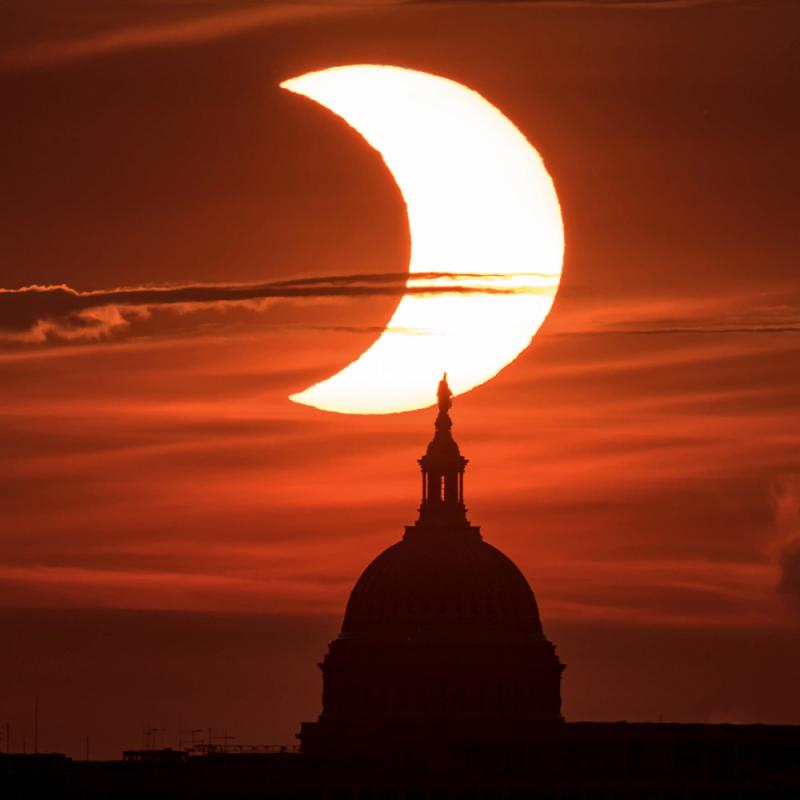 A partial eclipse with the silhouette of a building in front.