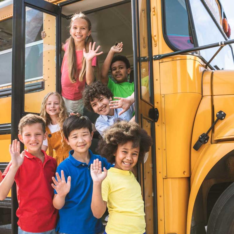 A group of kids getting on a bus for a field trip.