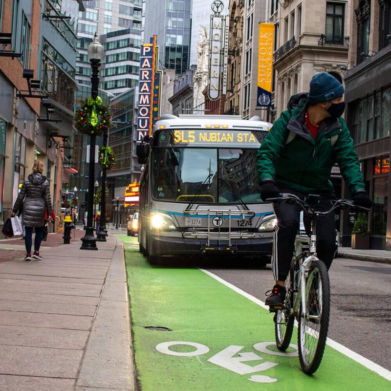 A biker riding through the streets of Boston.