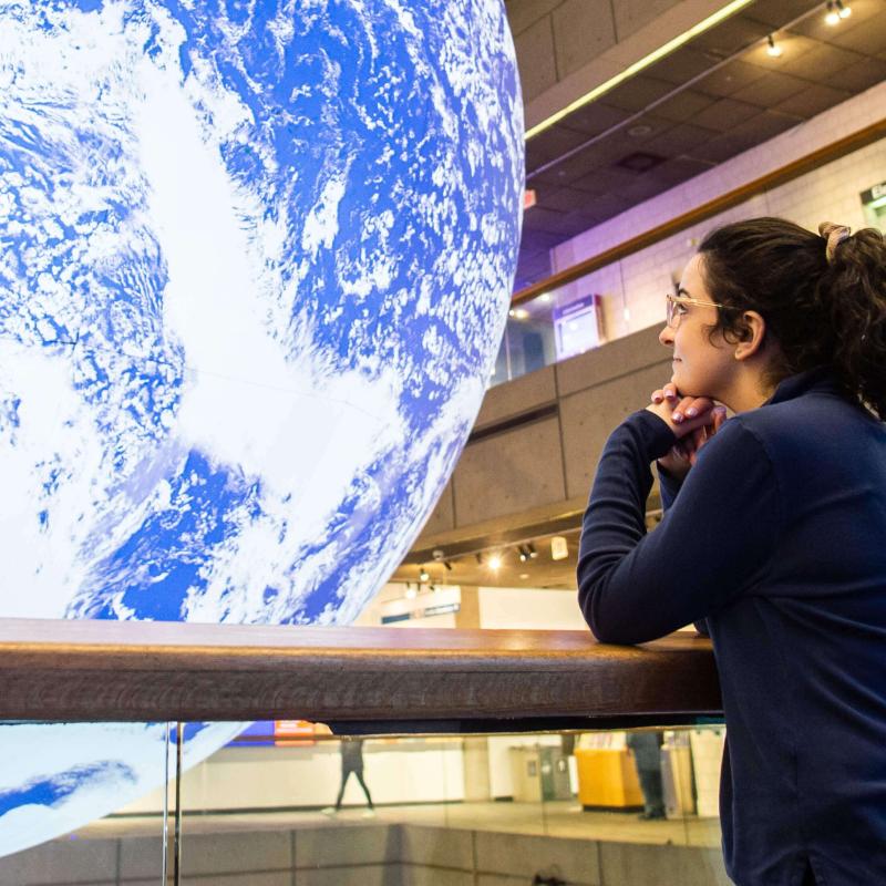 A guest looking out over the balcony of Level 2 at the Gaia installation.