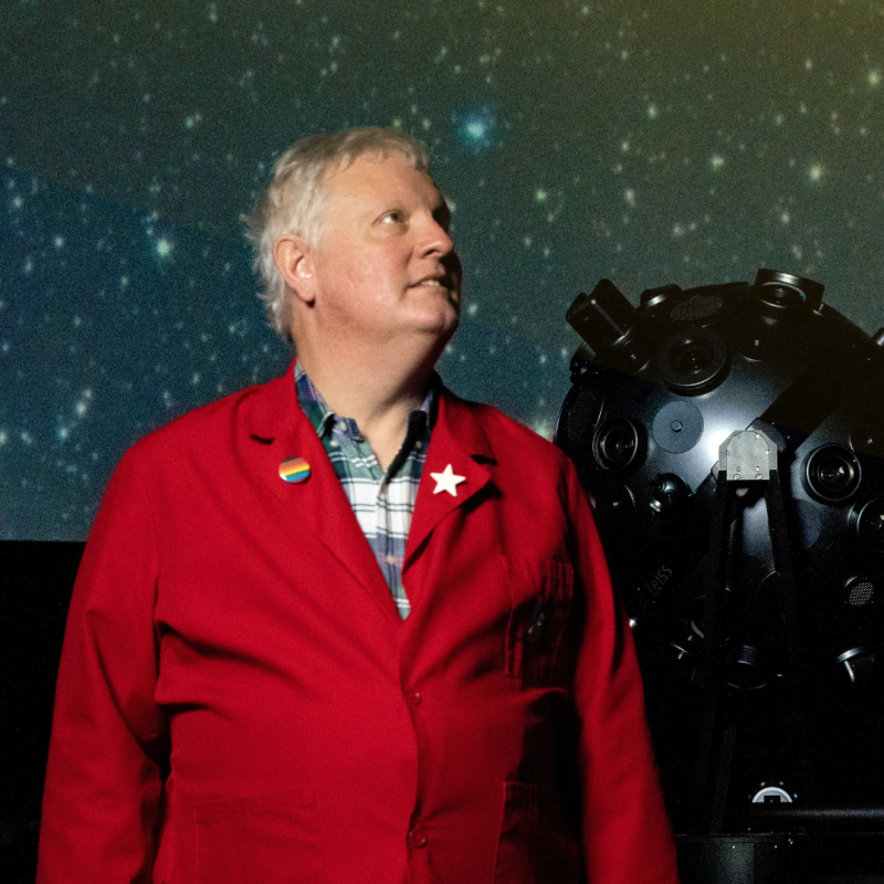 Chuck Wilcox in front of the planetarium projector