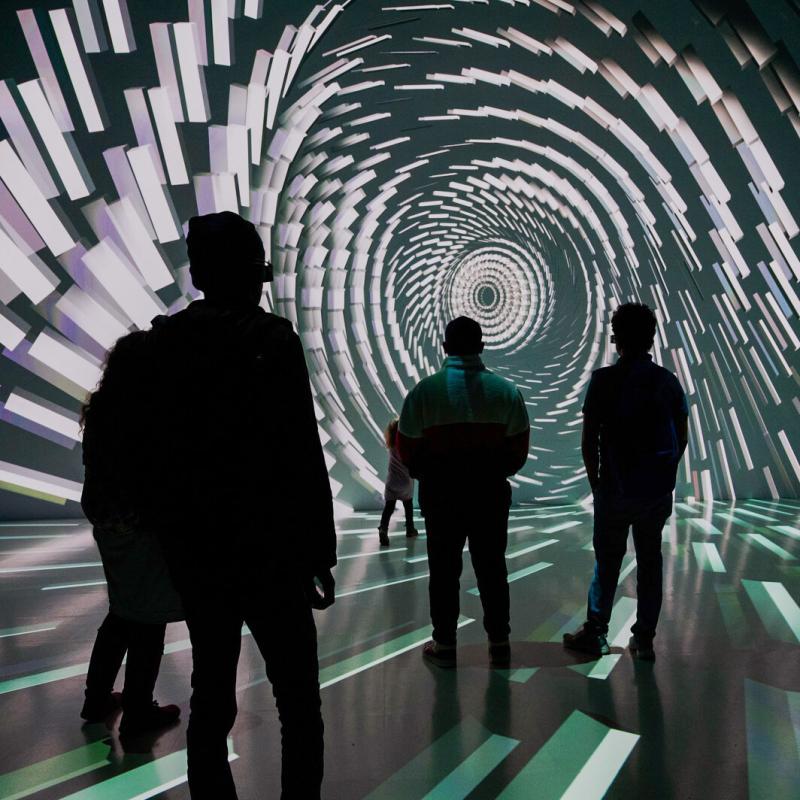 Visitors experiencing the Deep Space technology, with striking projections on the wall and floor.